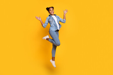 Fototapeta na wymiar Full body profile side photo of young african girl jump excited wear casual outfit wave hello isolated over yellow color background