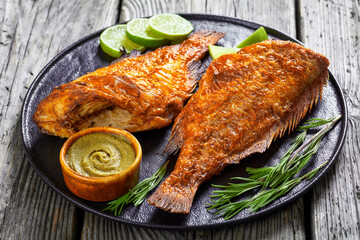 two fried ocean perch with rosemary and lime