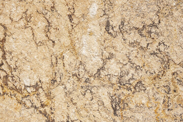 Old beige wall covered with uneven plaster. Texture of vintage shabby sand stone surface, closeup.