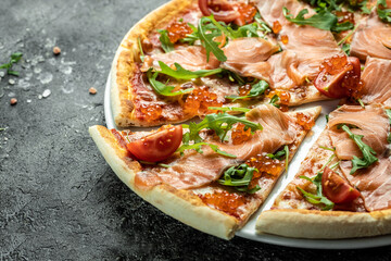 Delicious hot pizza with salmon, red caviar, tomatoes and aragula ready to eat. banner, menu, recipe place for text, top view