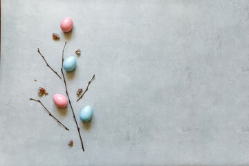 Happy Easter concept. Preparation for holiday. Colorful decorated easter eggs spring branches on concrete stone grey background. Simple minimalism flat lay top view copy space