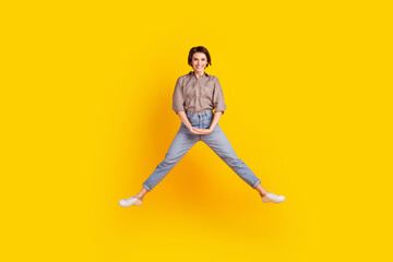 Full body photo of young pretty lady have fun jumper active dreamy isolated over yellow color background