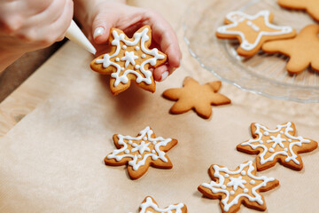 Ginger cookies in the hands decorated with icing