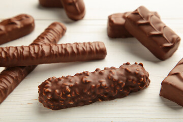 Mix of chocolate bars on white wooden background. Top view.