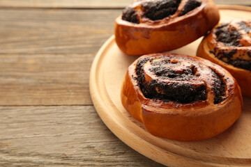 Bun with poppy seeds cutting board on brown wooden background.