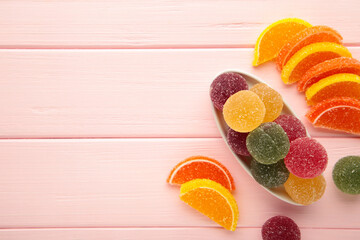 Jelly sugar candies in glass bowl on pink background.