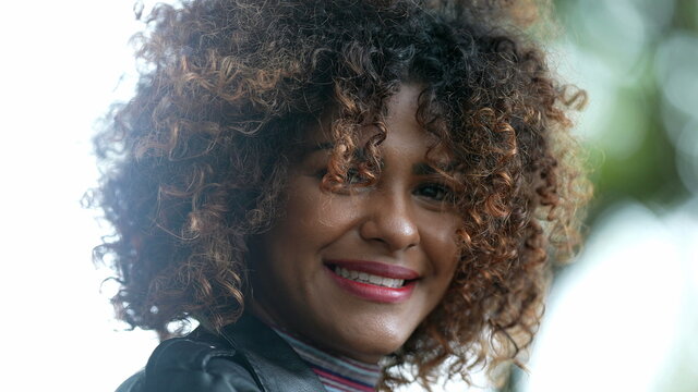 Brazilian black woman portrait close-up face looking at camera with curly hair
