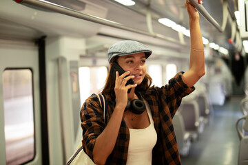 Young woman travelling by train. Beautiful girl talking to the phone while travel.