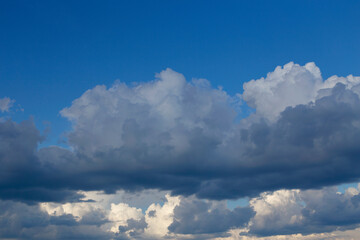 Naklejka na ściany i meble Close-up of huge white clouds and blue sky before rain. Rainy clouds