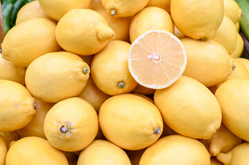 Fresh and delicious lemons for sale at vegetable market, close up. Boxes full of lemons in shop. Lemon at the greengrocer's stall. Fruit market.