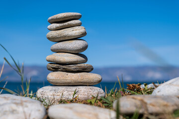 Pyramid of pebbles. Rock Zen in the background of the sea. Concept of harmony and balance.
