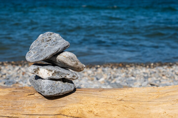 Fototapeta na wymiar Pyramid of pebbles. Rock Zen in the background of the sea. Concept of harmony and balance.