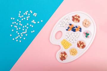 Global Pharmaceutical Industry and Medicinal Products - Different Colored Pills, Tablets and Capsules on White Art Palette Lying on Split Blue and Pink Background, Flat Lay