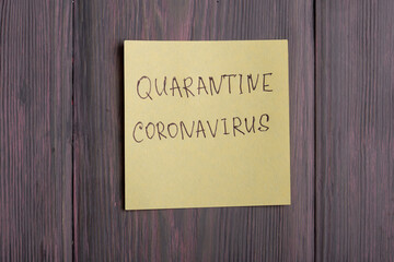 Text quarantine Coronavirus on sticky note on wooden background