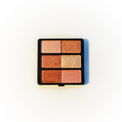 Mini palette of bronze and gold eyeshadows. Isolated image on a white background. Nobody.