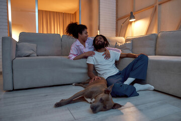 Woman hugging boyfriend who caressing sleeping dog