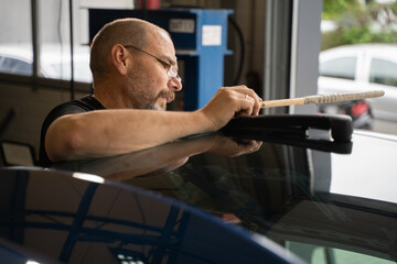 Professional Paintless Dent Repair Technician Is Repairing Dents On Car Body. Man Removing Dent On Car Trunk Lid After Hail. PDR Removal Course Training