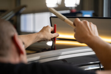 Process of Repairing Dents On Car Body. Technician Is Working Using Professional Tools For...