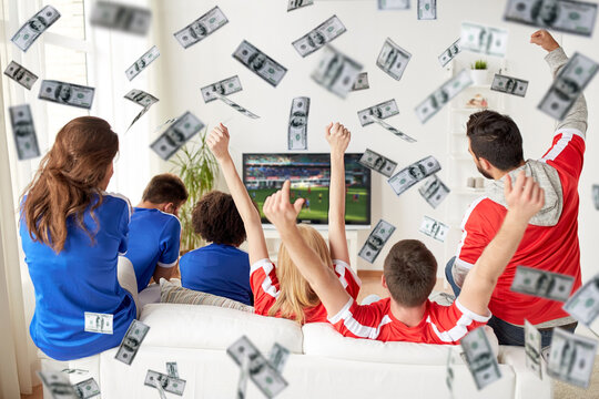 Online Betting, Gambling And Sport Concept - Happy Friends Or Football Fans Watching Soccer On Tv And Celebrating Victory At Home Over Money Rain