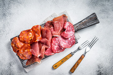 Assorted meat appetizers - salami, jamon, choriso sausages. White background. Top view
