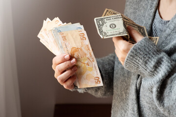 Turkish lira and dollar banknotes in woman hands. The paper currency of Turkey. Current Turkish liras are issued by The Central Bank of the Republic of Turkey. Financial crisis concept.
