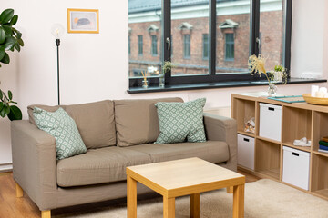 comfort, furniture and interior concept - sofa with cushions at cozy home living room