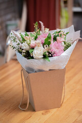 Bouquet of white roses and pink chrysanthemums in a package