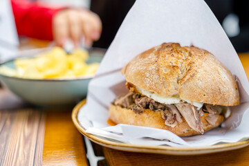 Delicious bun with delicate piglet and egg with chips aside