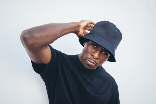 Young black man in street-style clothes posing with a serious facial expres