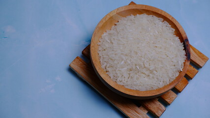 Rice in an oval wooden bowl and some kitchen ornaments neatly and beautifully arranged on a table. food and beverage concept. 