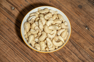 Dried cashew nuts in containers on wooden countertops