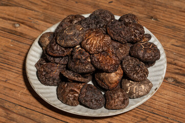 Dried mushrooms in a container on a wooden countertop