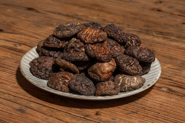 Dried mushrooms in a container on a wooden countertop