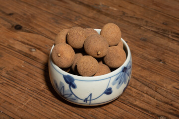 Dried longan in the container on the wood grain table