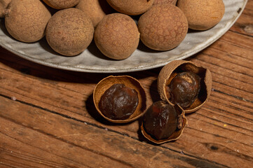 Dried longan in the container on the wood grain table
