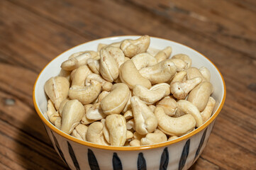 Dried cashew nuts in containers on wooden countertops
