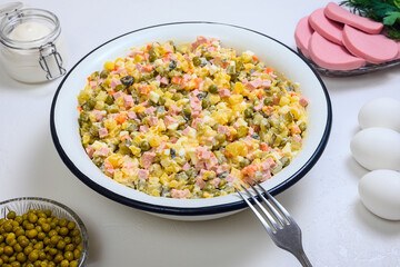 Russian Olivier in a large salad bowl on white background