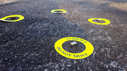 Bullet shell in middle of a yellow circle with text "evidence do not move" the circle on black background, concept for crime scene investigation