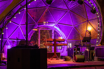 Purple transparent dome or bubble tent with musical instruments and illumination for a concert