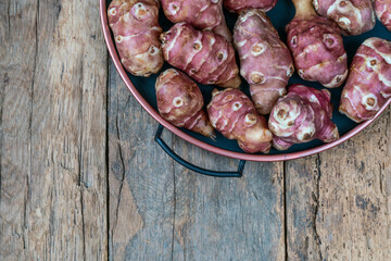fresh ripe Jerusalem artichokes on wooden table with copy space