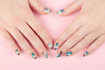 Obraz na płótnie Canvas Female hands with stylish manicure closeup. Colorful nail art on pink background.