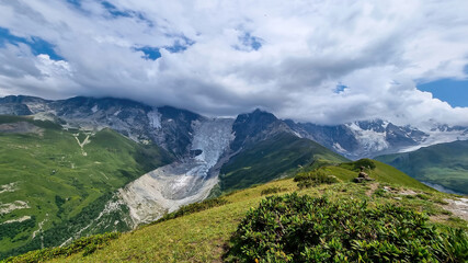 A panoramic view on the snow-capped peaks of Tetnuldi, Gistola, Lakutsia and the Adishi Glacier in the Greater Caucasus Mountain Range in Georgia, Svaneti Region. Sharp peaks, wanderlust, solitude.