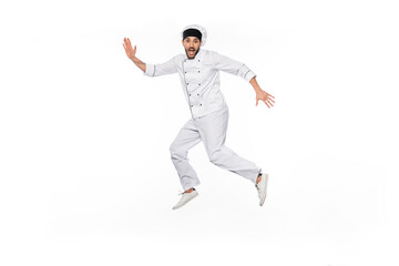 Fototapeta na wymiar excited chef in hat and uniform jumping isolated on white.