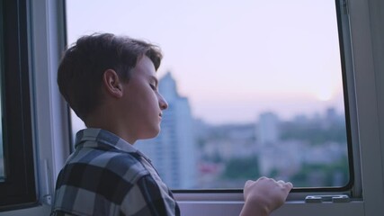 Unhappy teen boy looking through window, lonely child missing parents, bullying
