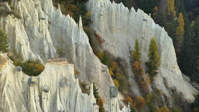 Aerial view on natural Earth Pyramids of Platten in autumn Dolomite Alps. Perca, Dolomites, Italy. UHD 4k drone video