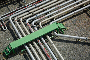 Top view steel long pipes and pipe elbow in tank station oil factory during refinery petrochemistry industry.