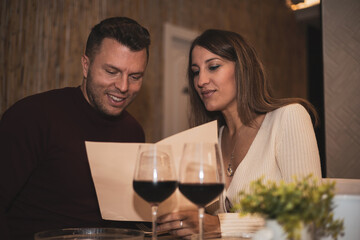 a wedding couple look at each other to order food in a restaurant.Valentine's Day