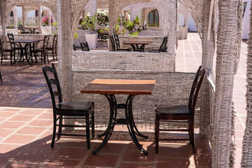 Fototapeta na wymiar Wooden table and chairs in beach cafe next to the red sea in Sharm el Sheikh, Egypt