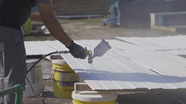 Close up of white paint sprayer on wooden planks