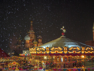 Red Square in Moscow, there is a merry fair carousel, a Christmas market, bright lights, on every...